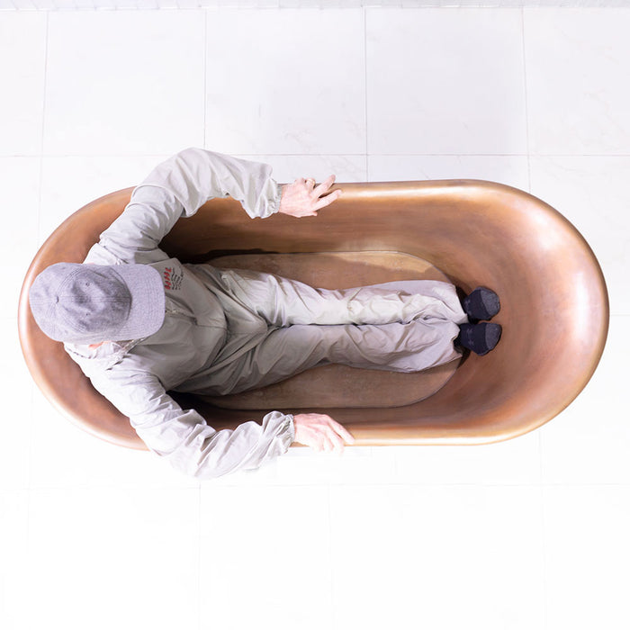 Body height comparison showing a person in “SanSiro Cognac 59BK” 59" Freestanding Satin Black Copper Tub